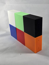 Load image into Gallery viewer, Six rectangular plastic blocks in different colors (white, green, black, blue, red, and orange) are arranged upright in two staggered rows on a white textured fabric background. The blocks form a stepped display, with the black and white blocks extending higher than the others. Small holes are visible on some faces of the blocks, suggesting they are enclosures, components, or assembly pieces. The photo is taken at an angle, showing the front and side surfaces of the colorful blocks.